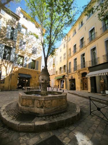 une fontaine avec un arbre au milieu d'une rue dans l'établissement New! Le zola studio lumineux en centre ville, à Aix-en-Provence