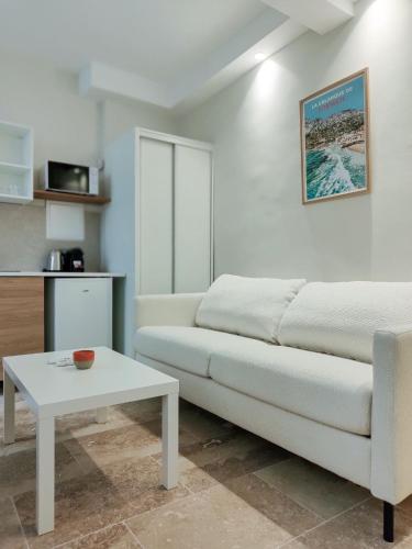 un salon avec un canapé blanc et une table dans l'établissement New! Le zola studio lumineux en centre ville, à Aix-en-Provence