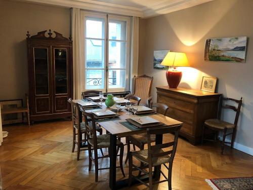 une salle à manger avec une table et des chaises et une fenêtre dans l'établissement Appartement T4 121 m2 Georges 1er centre-ville 3 chambres, à Aix-les-Bains