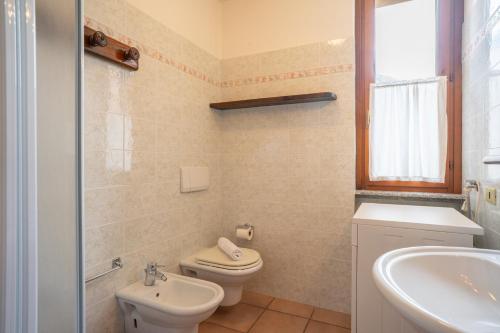 a bathroom with a toilet and a sink at Mountain lodging with fireplace and mountain view in Barzio