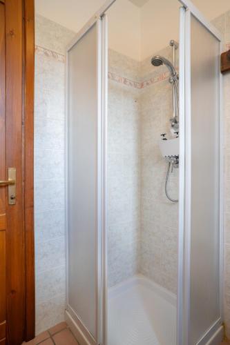 a shower with a glass door in a bathroom at Mountain lodging with fireplace and mountain view in Barzio