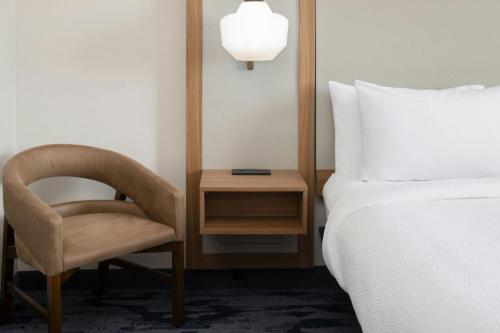 a bedroom with a bed and a chair and a side table at Fairfield by Marriott Inn & Suites Scottsdale Old Town in Scottsdale