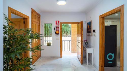 a hallway with two doors and a plant in a room at Villa Hole in One - GoLetMalaga in Mijas Costa