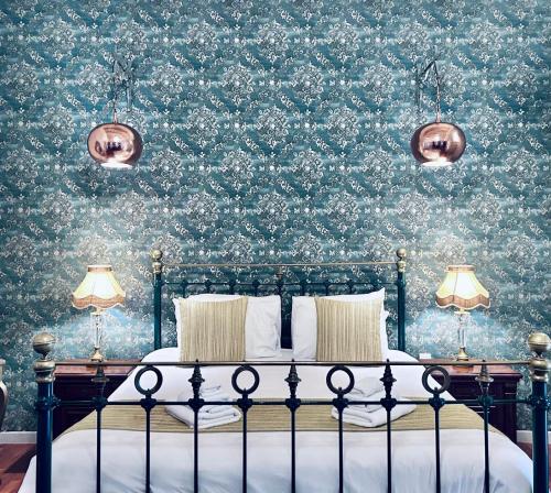 ein Schlafzimmer mit einem Bett mit geblümter Tapete in der Unterkunft Casa Birmula Boutique Hotel in Cospicua