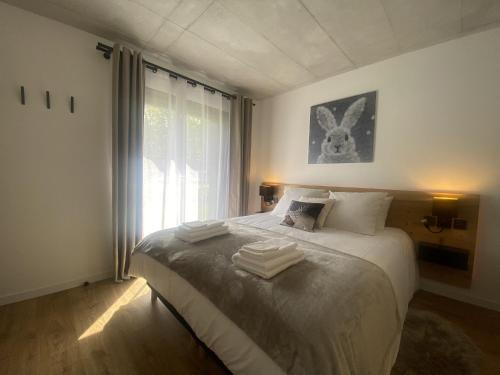 a bedroom with a bed with towels on it at Du Côté de Chez Sou in Arâches-la-Frasse