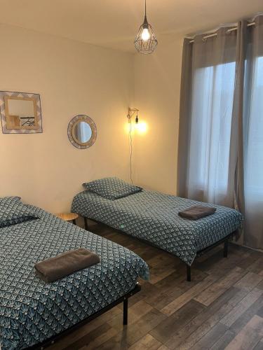 deux lits jumeaux dans une chambre avec fenêtre dans l'établissement Gîte du Haut Pilat, à Saint-Genest-Malifaux