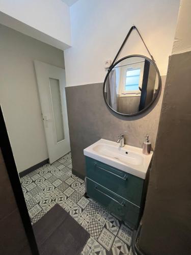 une salle de bain avec un lavabo et un miroir dans l'établissement Gîte du Haut Pilat, à Saint-Genest-Malifaux