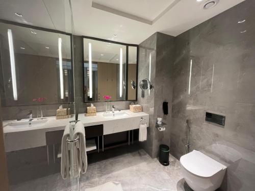a bathroom with two sinks and a toilet and a shower at Taj Cochin International Airport, Kerala in Cochin