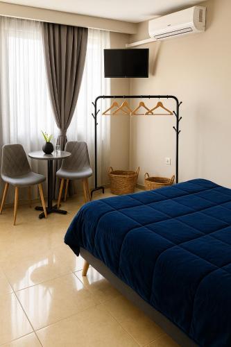 a bedroom with a blue bed and a table and chairs at Sunny apartment in Serres
