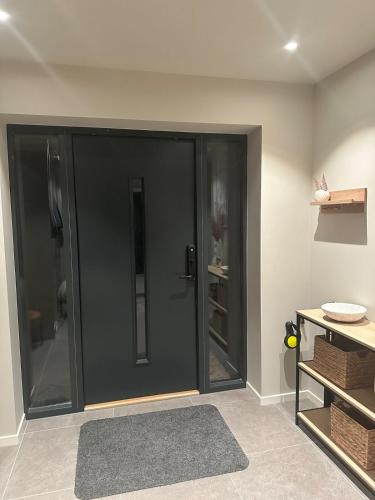 a large black door in a room with a rug at Melø Panorama design home with magical views in Larvik