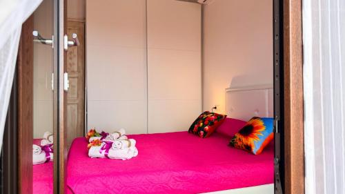 een kamer met een roze bed met knuffels erop bij La casa delle Stelle by Ca-Sa Check in San Teodoro