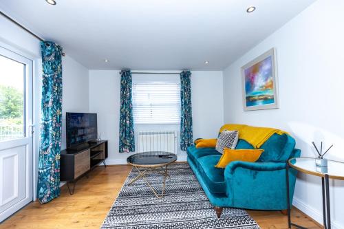 a living room with a blue couch and a tv at First Class Flat in Brandon