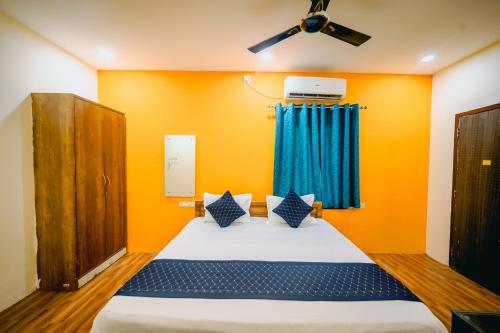 a bedroom with a bed and a ceiling fan at Hotel Laughing Buddha in Bhubaneshwar