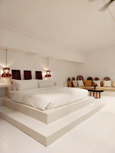 a large white bedroom with a large white bed at Beautiful La Shanti 1 bed villa in Kerobokan