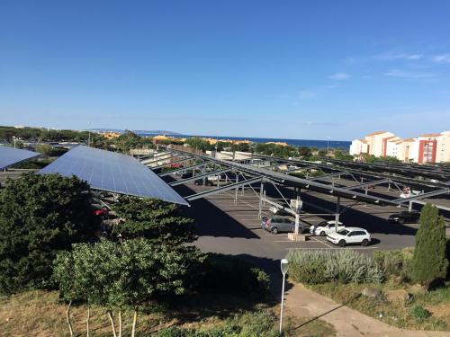 une vue aérienne d'un parking avec un solarium dans l'établissement T2 bien situé, au Cap d'Agde