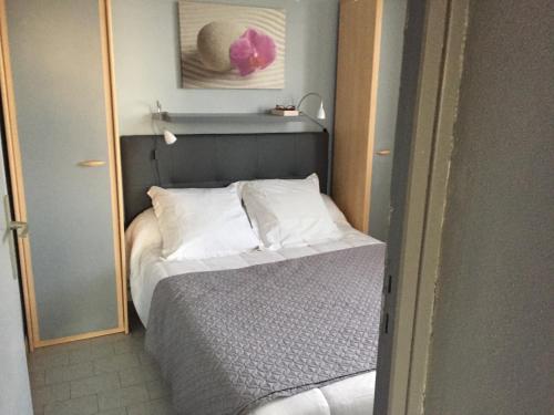 une petite chambre avec un lit et un miroir dans l'établissement T2 bien situé, au Cap d'Agde