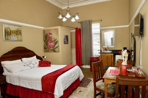 a bedroom with a bed and a table with a table at Heidelberg Guesthouse in Heidelberg