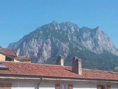 a mountain in front of a house with a roof at Authentic yet modern retreat in Lecco center in Lecco