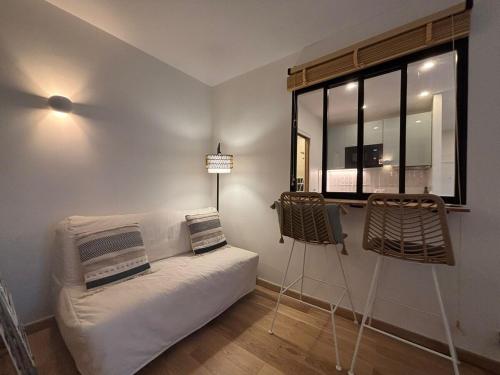 un salon avec un canapé et une fenêtre dans l'établissement Casimir, à Paris