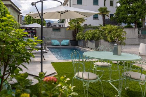 a patio with a table and chairs next to a pool at Maji Como Lake in Mandello del Lario