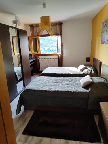 a bedroom with two beds and a window at Casa das Argolas in Macedo de Cavaleiros