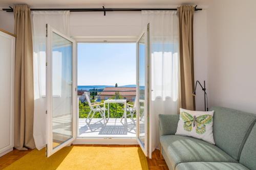 a living room with a couch and a sliding glass door at Studio Point of view in Punat