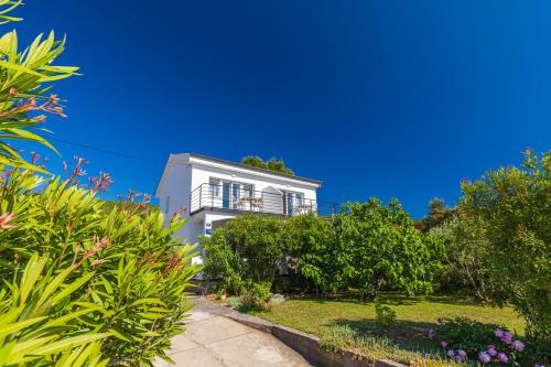 a white house with trees and plants at Studio Point of view in Punat