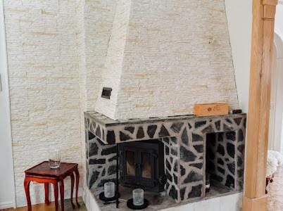 a stone fireplace in a living room with a table at Paradise-Silvergruvan in Hällefors