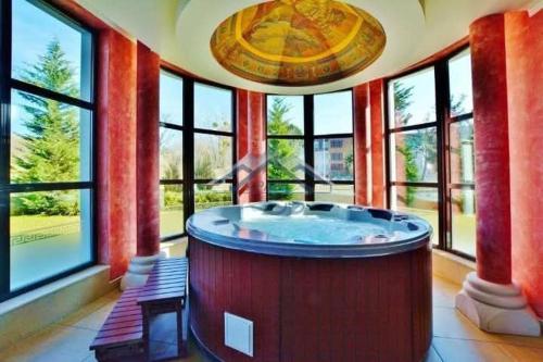 a large room with a large tub in a room with windows at Тематичен Пентхаус Несебър България in Nesebar