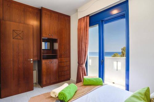 ein Schlafzimmer mit einem Bett und einem großen Fenster in der Unterkunft Villa Matina by Villa Plus in Lindos