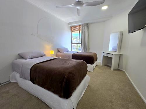 a bedroom with two beds and a television in it at Deluxe Two Bedroom Apartment with Ocean Views in Coolum Beach