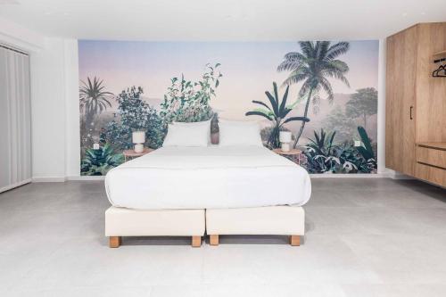 a bedroom with a white bed and palm trees mural at Kamelia Villa 1 in Hersonissos