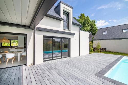 une terrasse avec une piscine et une maison dans l'établissement Villa de la Grée, à Sarzeau