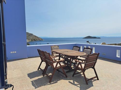 una mesa de madera y sillas con vistas al océano en Aegean Balconies in Vromolithos Beach, Leros, en Vromolithos