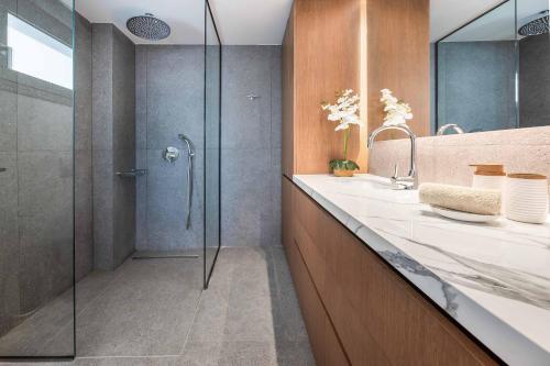 un baño con ducha y lavabo en Kamelia Villa 3, en Hersonissos