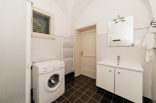 a bathroom with a washing machine and a sink at CASA PAPADIA in Uggiano la Chiesa