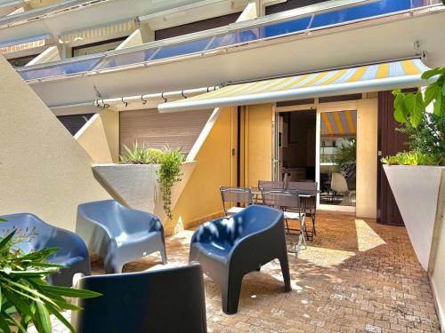 un patio avec des chaises et des tables dans un bâtiment dans l'établissement Helio O5, séjour calme et relaxant, au Cap d'Agde