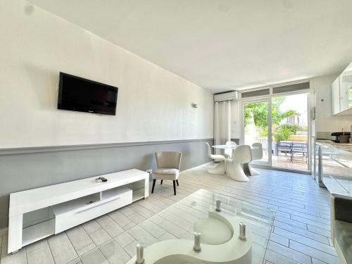 un salon avec une télévision sur un mur dans l'établissement Helio O5, séjour calme et relaxant, au Cap d'Agde