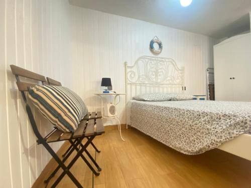 a bedroom with a bed and a chair in it at Casa del Pescador in L'Ametlla de Mar