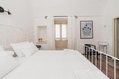 a white bedroom with a large white bed at CASA PAPADIA in Uggiano la Chiesa