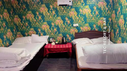 two beds in a room with green wallpaper at TEC Resort and bar in Dharān Bāzār