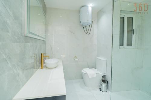 a white bathroom with a toilet and a sink at Homey 1BR home with Balcony in Heart of Malta by 360 Estates in Birkirkara