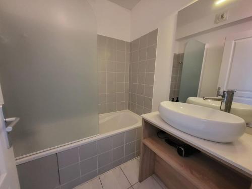 une salle de bain avec un lavabo et une baignoire et un lavabo dans l'établissement La terrasse de Babylone, calme et relaxant, au Cap d'Agde