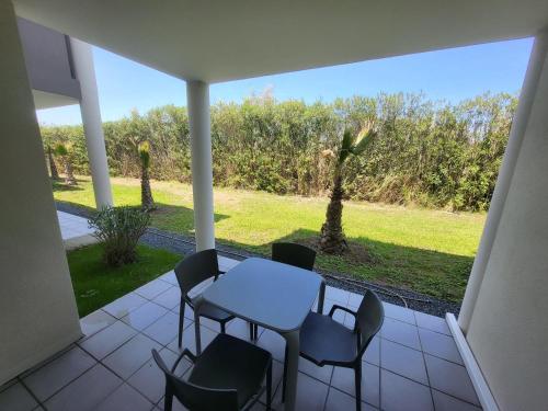 une table et des chaises sur une terrasse avec vue dans l'établissement La terrasse de Babylone, calme et relaxant, au Cap d'Agde