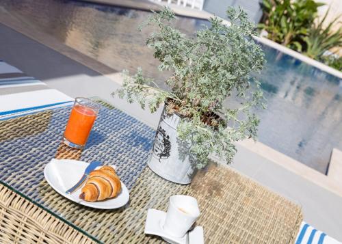 a table with a plate of croissants and a vase at BB De Rohan in Żebbuġ