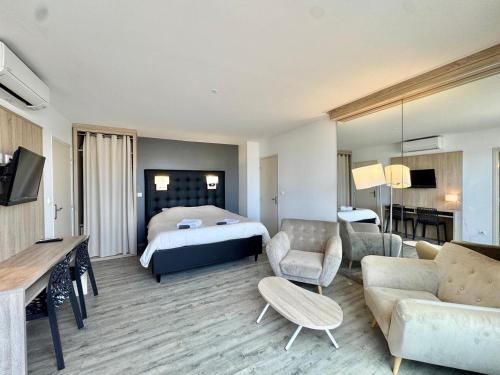 une chambre d'hôtel avec un lit et un salon dans l'établissement La terrasse d'Eden, calme et relaxant, au Cap d'Agde