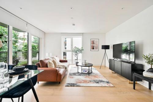 a living room with a couch and a table at Luxury 2BR Apartment - West London, Steps to Tube & Westfield Mall in London