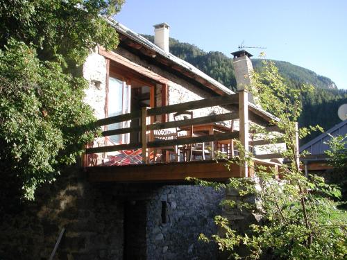 a building with a balcony on the side of it at Le Gite de la Passerelle à Crévoux in Crévoux