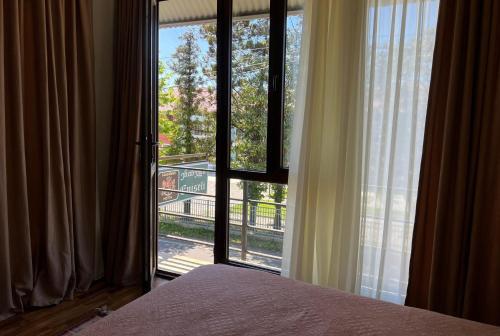 a bedroom with a bed and a large window at Eniseli in Chakvi