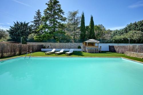 - une piscine avec 2 chaises longues et un kiosque dans l'établissement Villa Harmonie, au Beausset